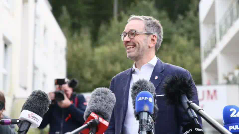 Getty Images Herbert Kickl, Chairman of Far-right Freedom Party of Austria (FPO) speaks to press members after casting his vote in general elections in Vienna